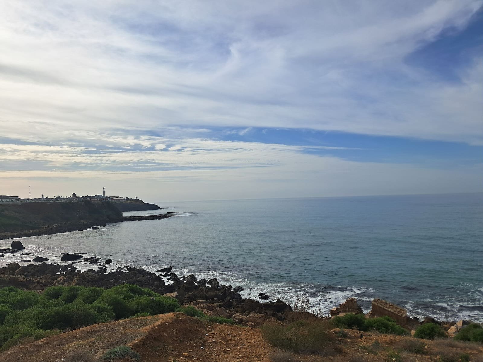 The Atlantic coast of Larache, Morocco, with waves rolling onto the rocks below the headland