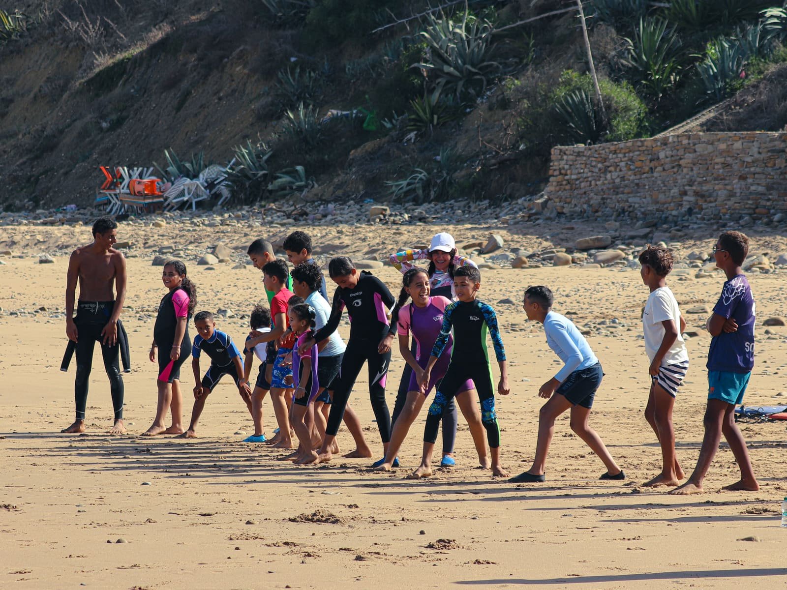 Kids and instructors lined up on the beach for a warm-up before getting in the water