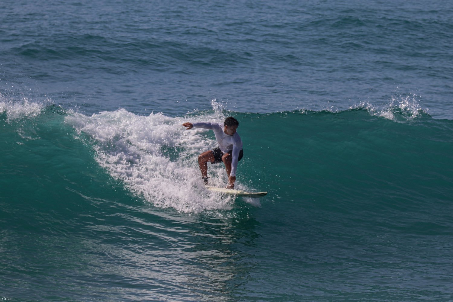 A surfer riding along an open green wall of water on the Atlantic coast
