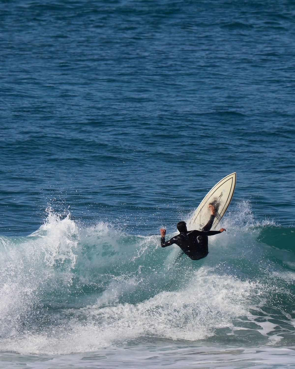 A surfer hitting the lip of a wave and throwing spray